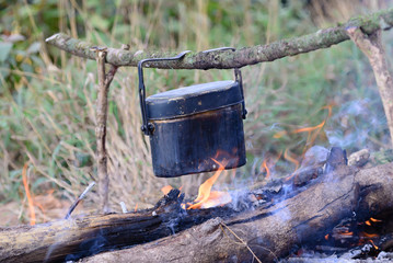 Cooking with cauldron on campfire.