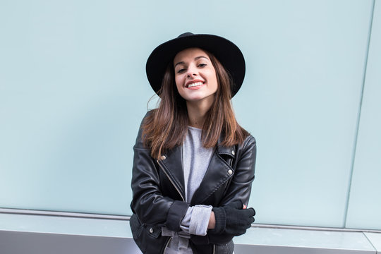 Young stylish woman against a blue wall in the street