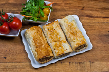 Meat and vegetable pies on the wooden table
