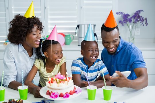 Family looking at picture while celebrating birthday party