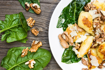 Roasted Potatoes, Celery and Walnuts with Fresh Salad Leaves on White Plate. Top View Healthy Food...
