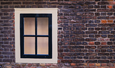 Window with white edge surrounded by brickwall background