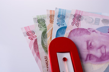 Turkish Lira banknotes by the side of a red color temperature
