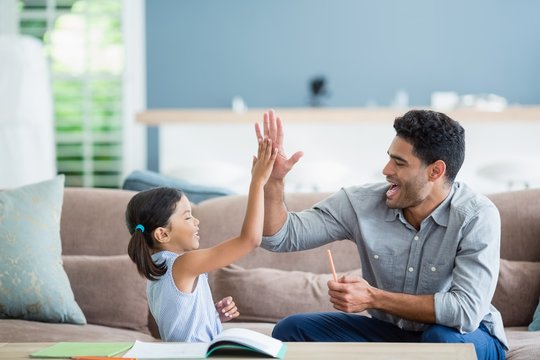 Father giving high five to his daughter 