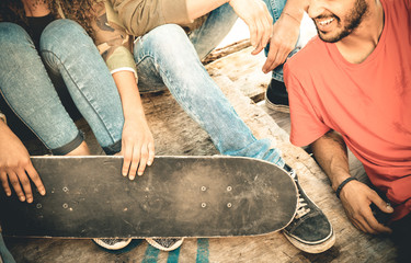 Group of multiracial friends having fun and spending time together at skate board park - Youth...
