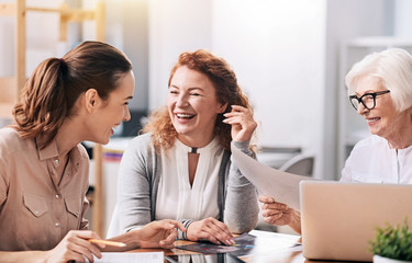 Laughing businesswomen sharing ideas at work