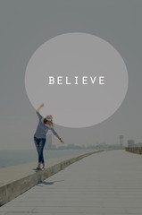 Beautiful young hipster woman walking near sea with raised hands. Oval insert with believe sign