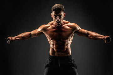 bodybuilder posing. Beautiful sporty guy male power. Fitness muscled man. Roar