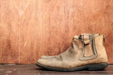 Old boots on wooden table.