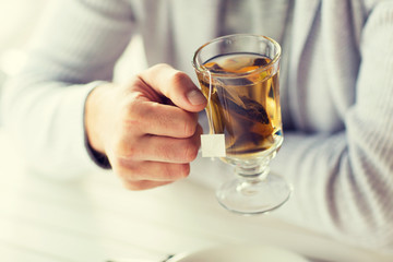close up of man drinking tea at home or cafe