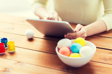 close up of woman with tablet pc and easter eggs