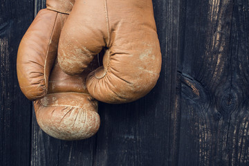 Boxing gloves hanging on old wooden door.