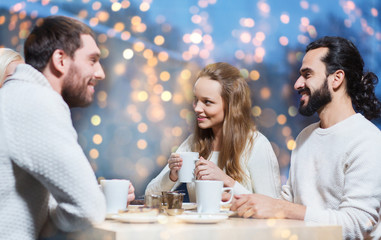happy friends drinking tea at cafe