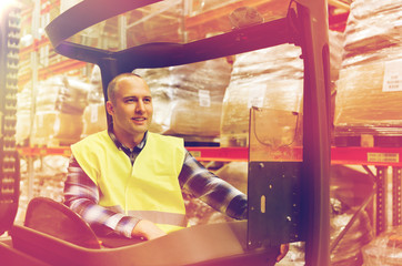 smiling man operating forklift loader at warehouse