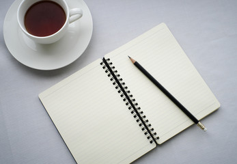 Coffee in white cup with Journal book and pencil