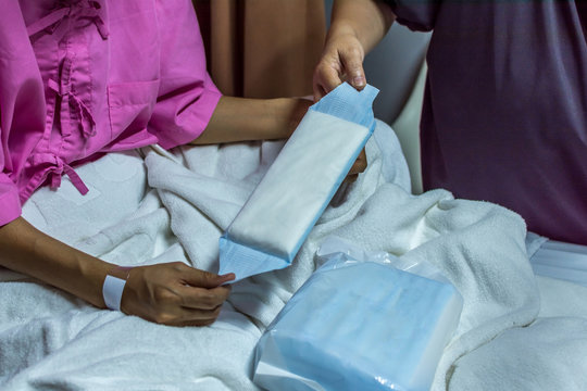 Patient Woman Using Sanitary Napkin On Bed