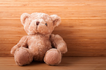 Teddy bear on wooden table.
