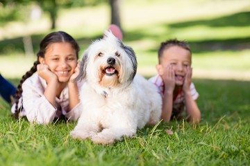 Portrait of siblings having fun with their pet dog