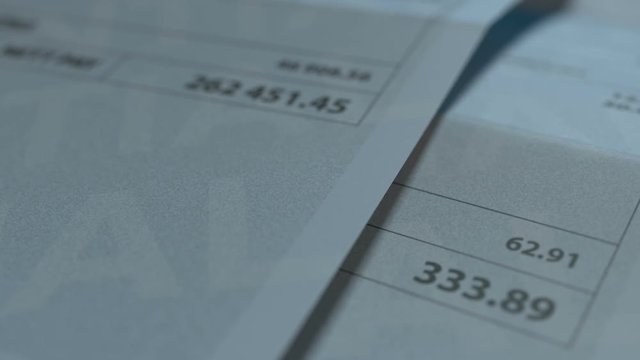 A pan and rack focus shot showing  two fictitious paychecks with a huge difference in the nett pay highlighting the income inequality created by capitalism