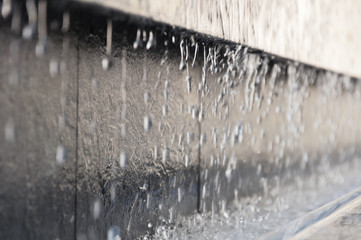 part of the fountain with falling water drops as background