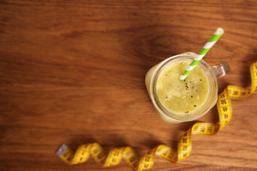 Smoothies of kiwi, spinach, celery, apples on a wooden table with tape meter, sports themes, diet.
