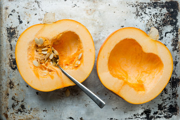 Pumpkin Halves and Spoon on Aluminum Surface