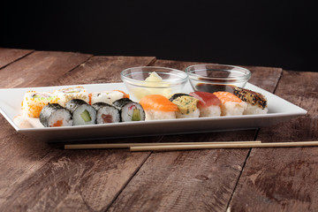 close up of sashimi sushi set with chopsticks and soy - sushi roll with salmon and sushi roll with smoked eel, selective focus.