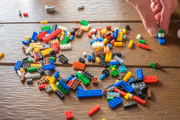 Colored plastic construction blocks with woman's hand