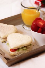 Vegan heart sandwich served in a tray with juice and cherry tomatoes / Healthy valentine Breakfast concept