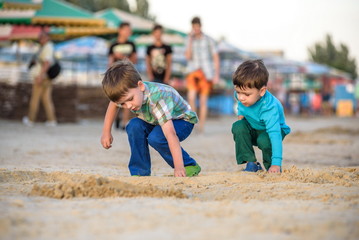 Two happy caucasian kids, brothers, playing together with toy ca