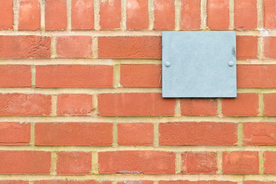 Brick Wall Pattern With Blue Metal Plaque