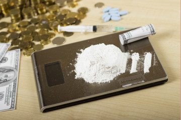 Close-up of a hand holding money over a heroine pile. Drugs in powder on a digital scale. Man about to snort in the drugs. Drugs and crime concept.