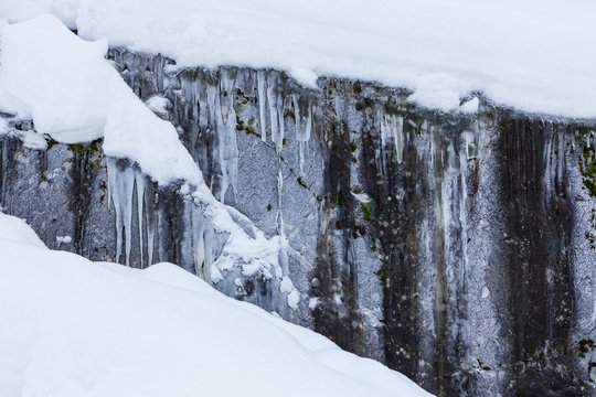 ice and snow covered rock cliff