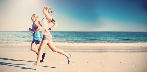 Side view of friends jogging at beach