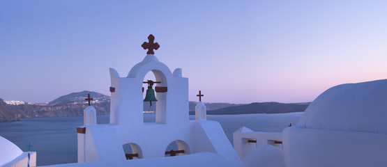 Bell tower of the local church in Oia village in the evening, pa