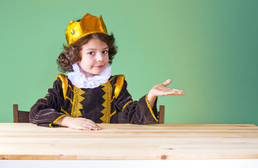 Young pretty kinky Prince keeps his hand on an imaginary object, cute smile, looking into the...