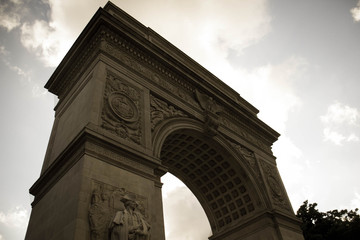 Washington Square Park Arch with cloudy sky in dark vintage style