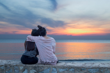 Women sit back hug