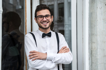 Groom in white shirt smiling near the window