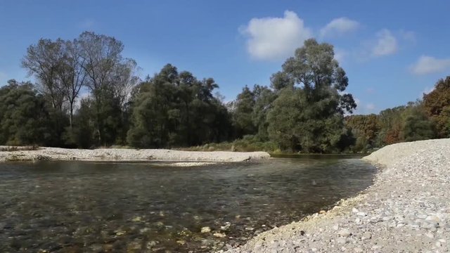 Corso del fiume accellerato su un letto di sassi con cielo azzurro