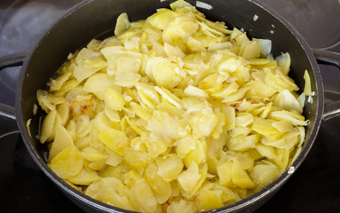 Preparing a traditional spanish omelette on frying pan.  Spanish cuisine