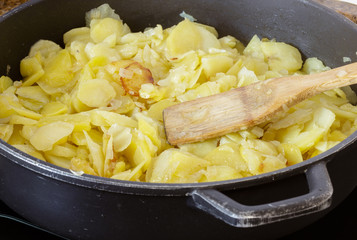Preparing a traditional spanish omelette on frying pan. Spanish cuisine