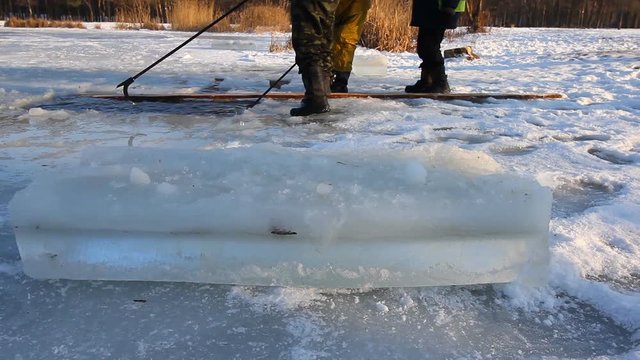 Water spreads around as ice is being sawn for ice sculpture with a powerful chainsaw at a frozen lake on February