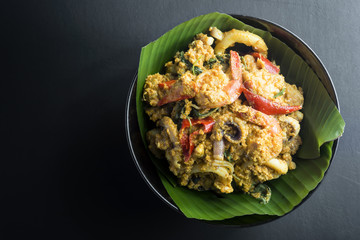 steamed fish with curry paste on black background.
