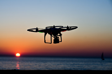 Fototapeta na wymiar Flying drone with camera on the sky at sunset