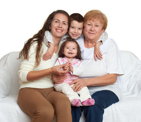 Family portrait on white background, happy people sit on sofa. Children with mother and grandmother