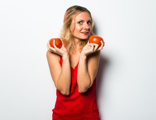 Beautiful blonde woman holding tomatoes