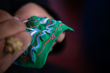 artist's hand painting thai traditional mask using for ramayana dance 