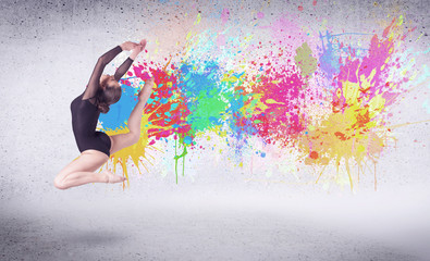 Fototapeta na wymiar Modern street dancer jumping with colorful paint splashes
