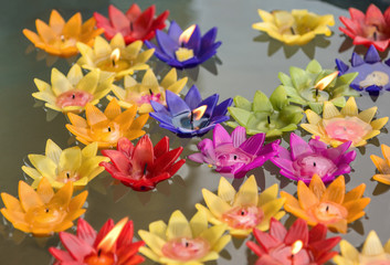 The colorful candles floating on the water.